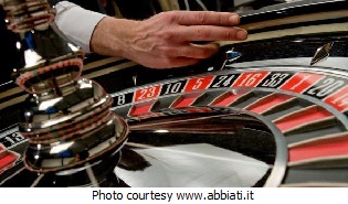 Casino roulette wheel, dealer about to spin the wheeel.
